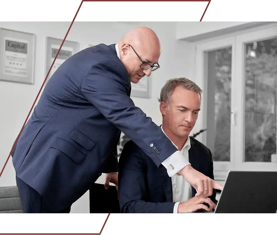 ein Mitarbeiter zeigt auf einen Bildschirm